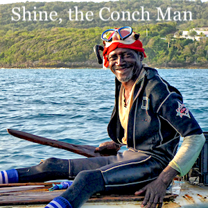 Shine, the Conch Man, sitting on his board at sea