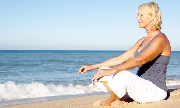 woman sitting on the beach in yoga pose