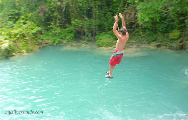 jumping into the first blue hole from the swing over the waterfall