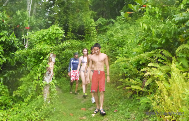 walking through lush vegetation to more waterfalls and blue holes