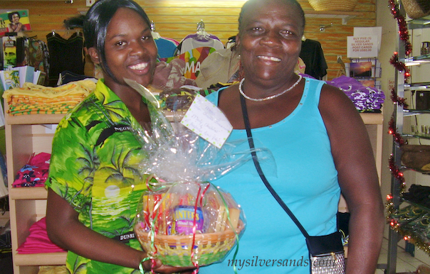 Mavis Davis of Nutshell receives her Christmas gift basket from kwesi of Villa Mart, SIlver Sands Jamaica