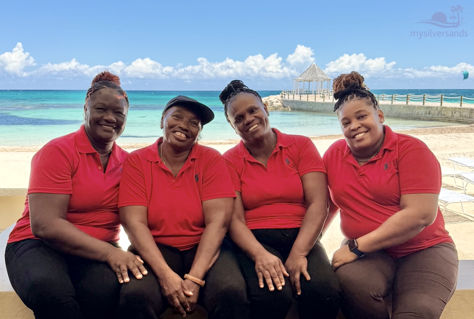 rum jetty staff sitting on the verandah with the beach and sea in the background