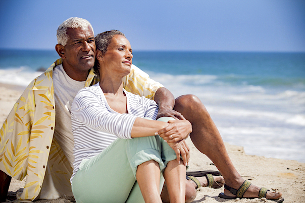 mature couple sitting on beach