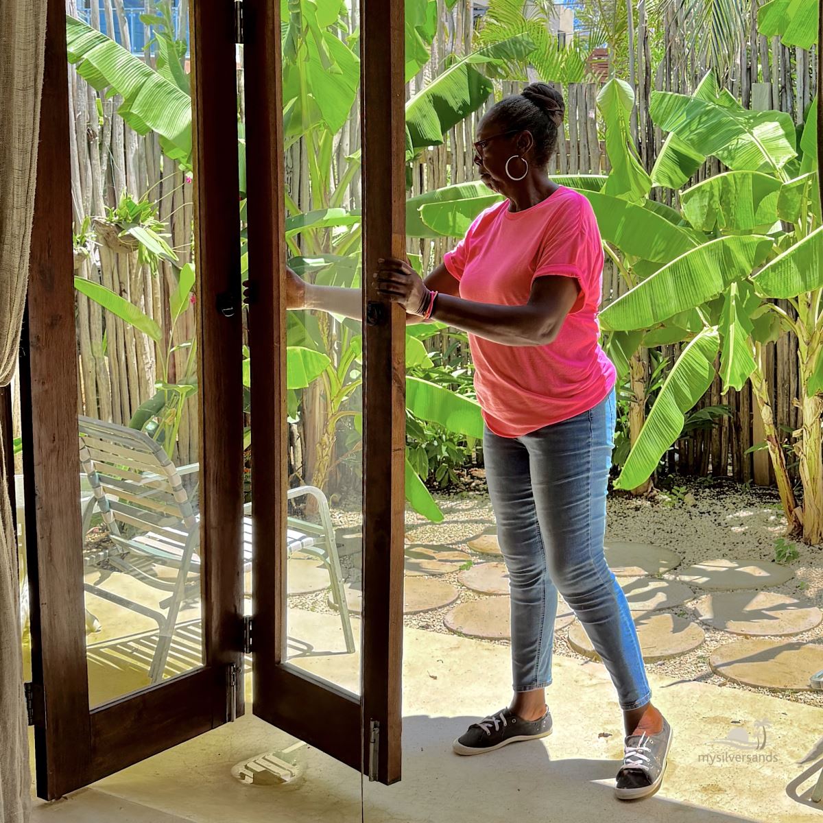 Marcia opening the bedroom doors which lead to its private garden