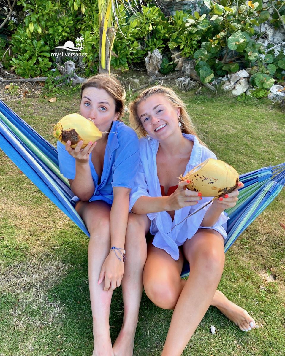 2 girls in hammock with coconuts