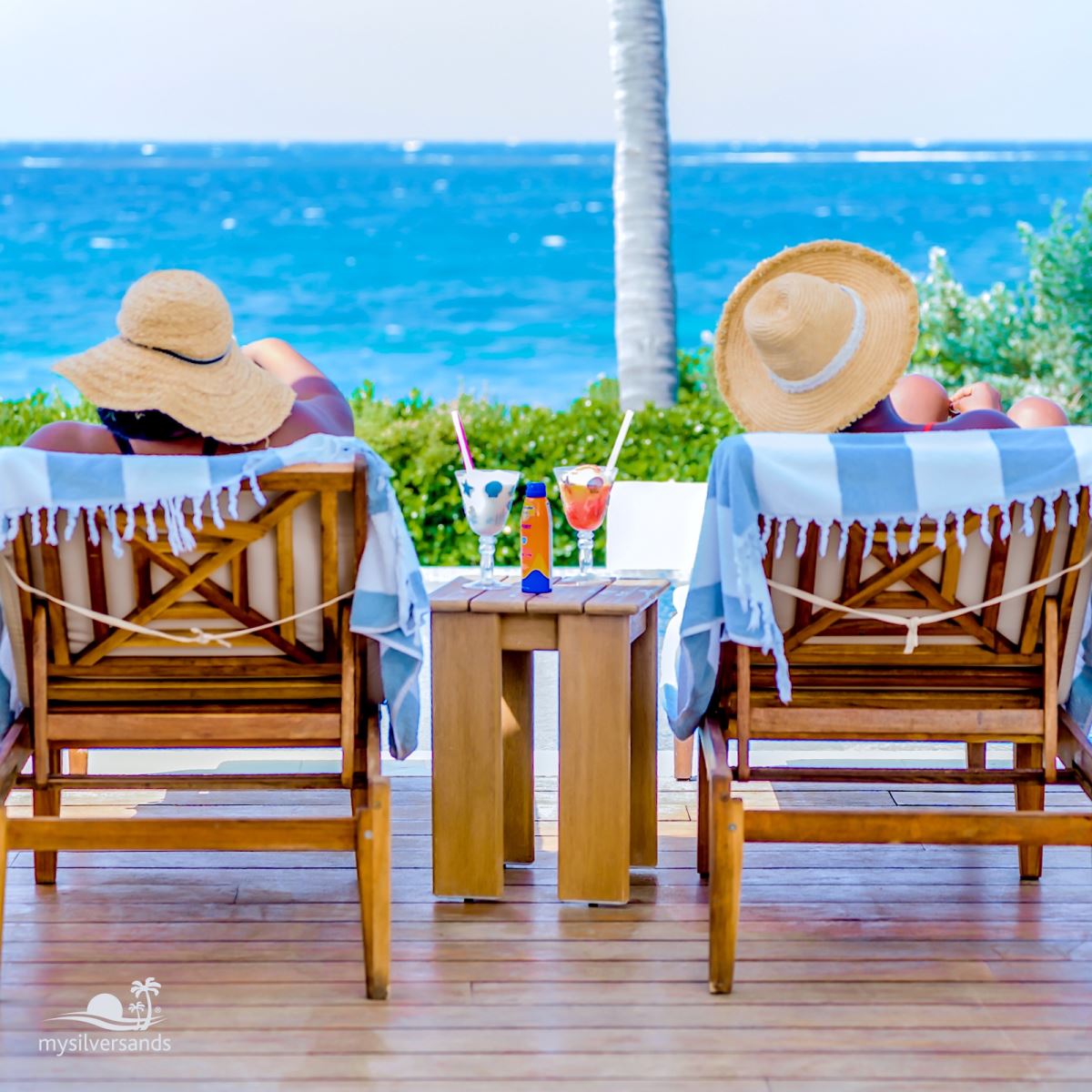 2 lounge chairs on the pool deck with sea view