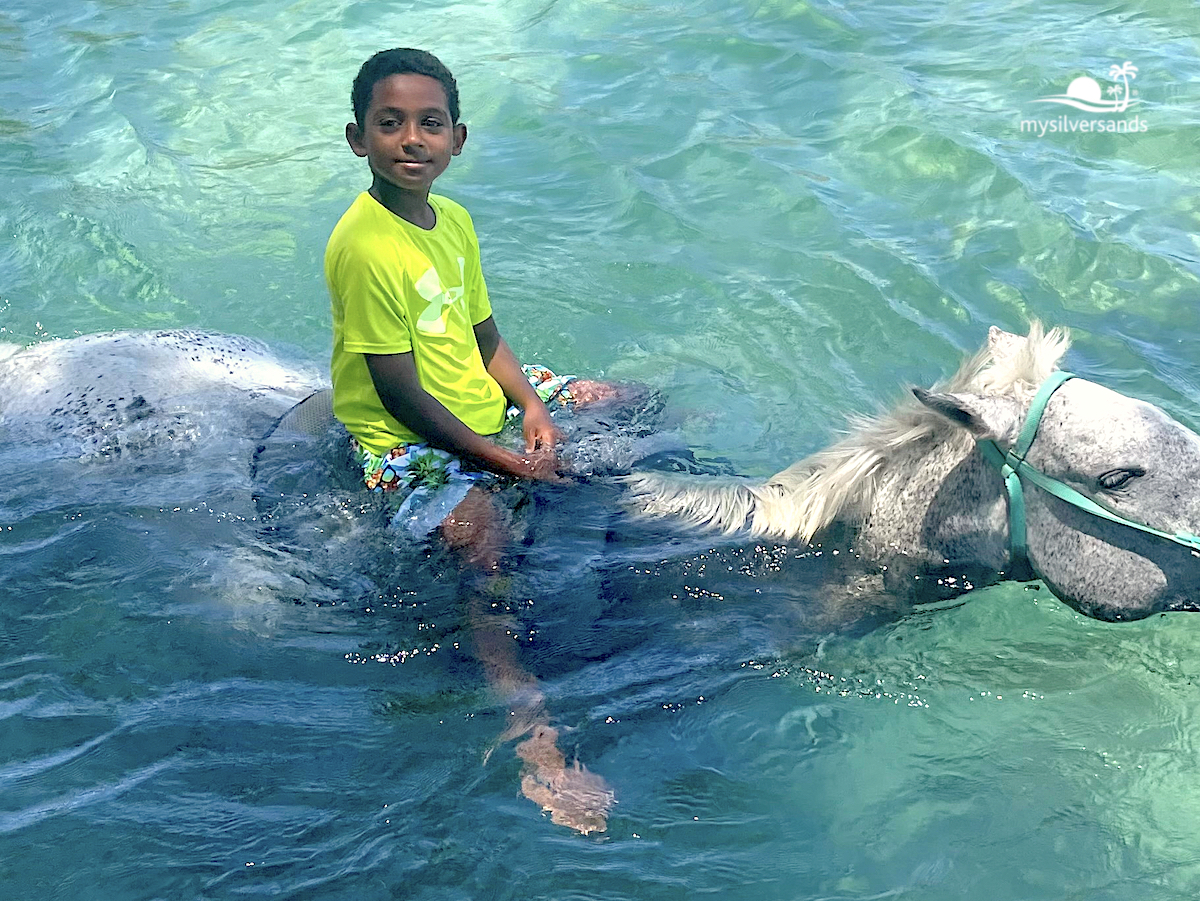 boy on horseback in the sea