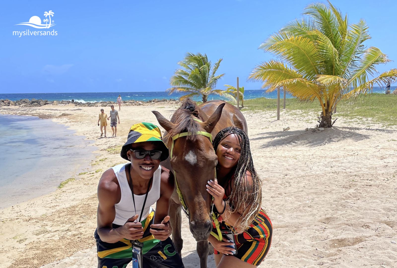 man and woman on the beach posing with horse
