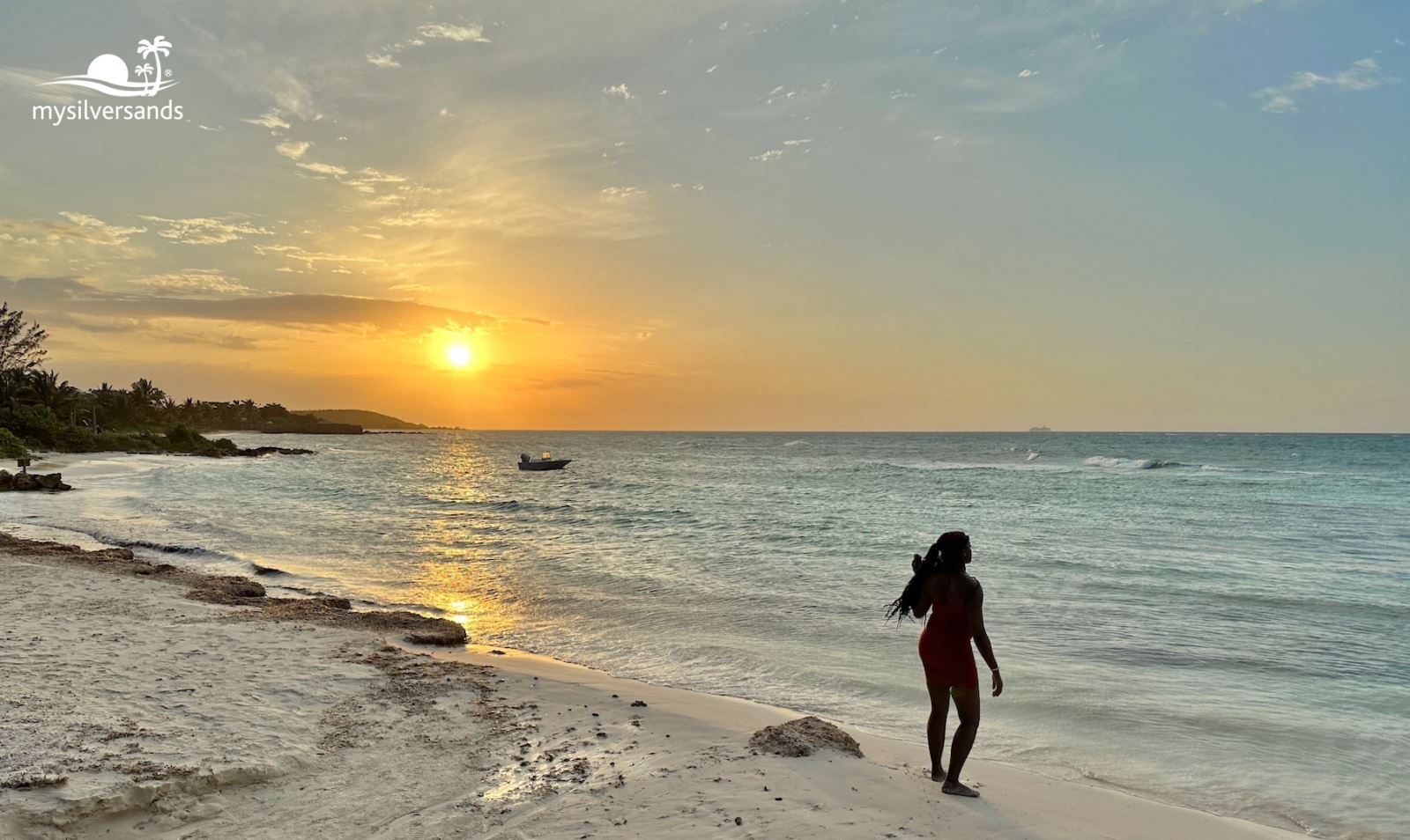 woman standing on the beach at sunset