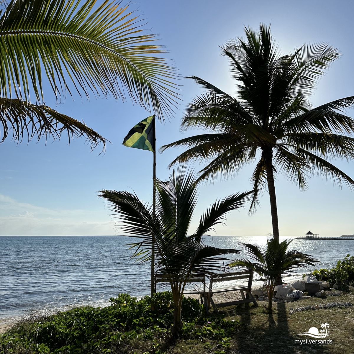 west beach with bench and jamaican flag