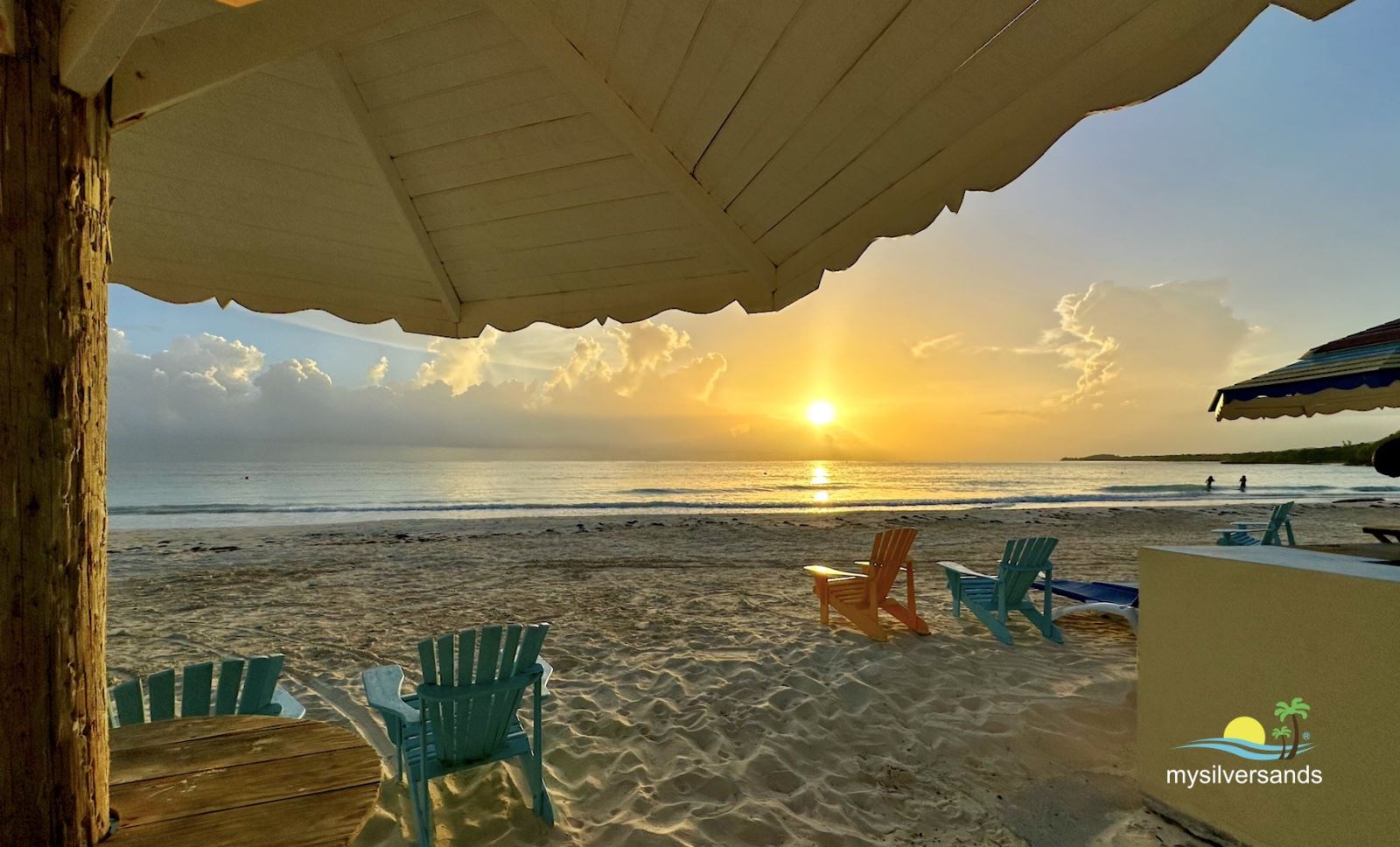under cabana at sunrise with swimmers
