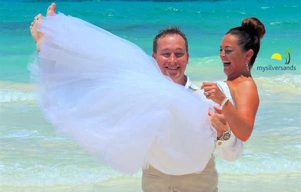 groom carrying bride on the beach
