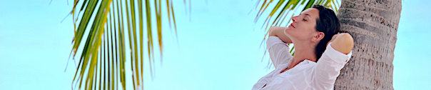 woman leaning against coconut tree