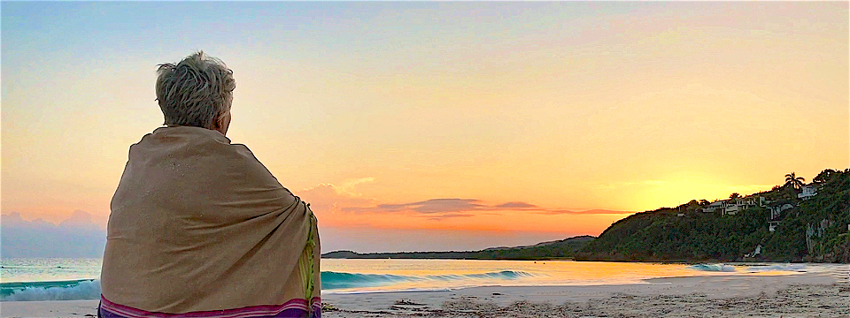 lynn sitting on the beach watching the sunrise