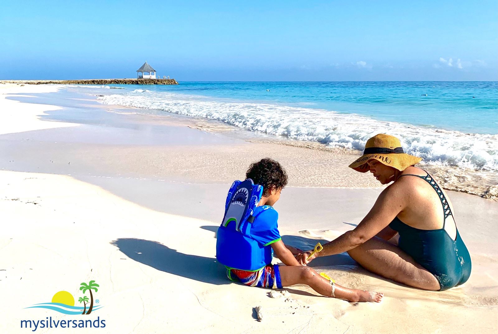 mother and child sitting on the beach at silver sands