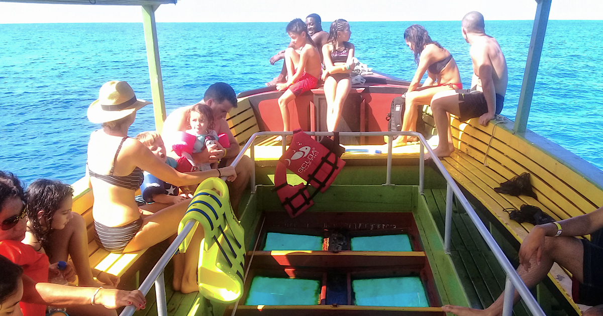 people in glass bottom boat at sea