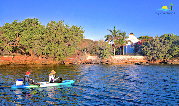 lea and randy paddle their kayak past saint mark's anglican church