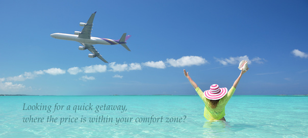 woman in sea, arms in the air, with plane flying above