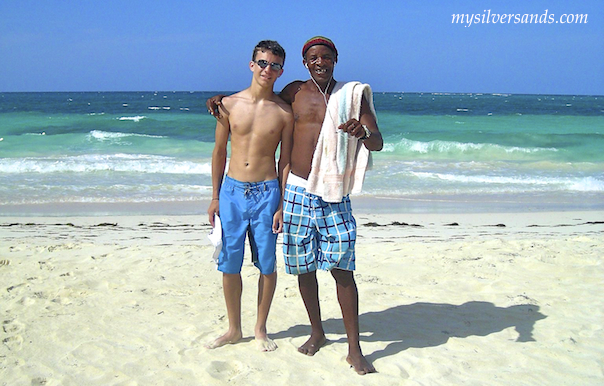 bailey with roy, lifeguard, on the silver sands beach in jamaica