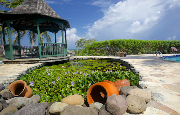 large clay jars and river rocks decorate the lily pond